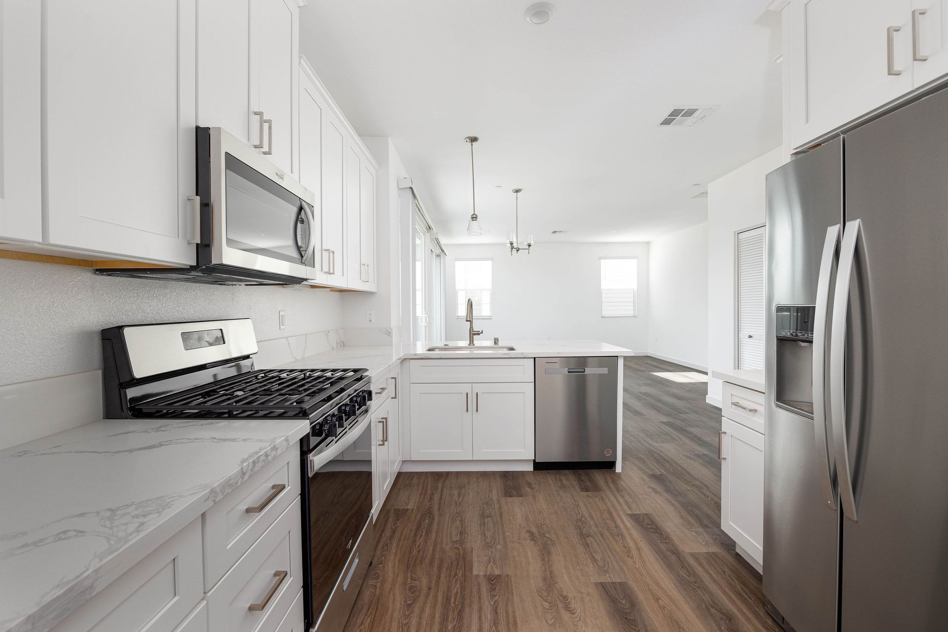 a kitchen with white cabinets and stainless steel appliances .