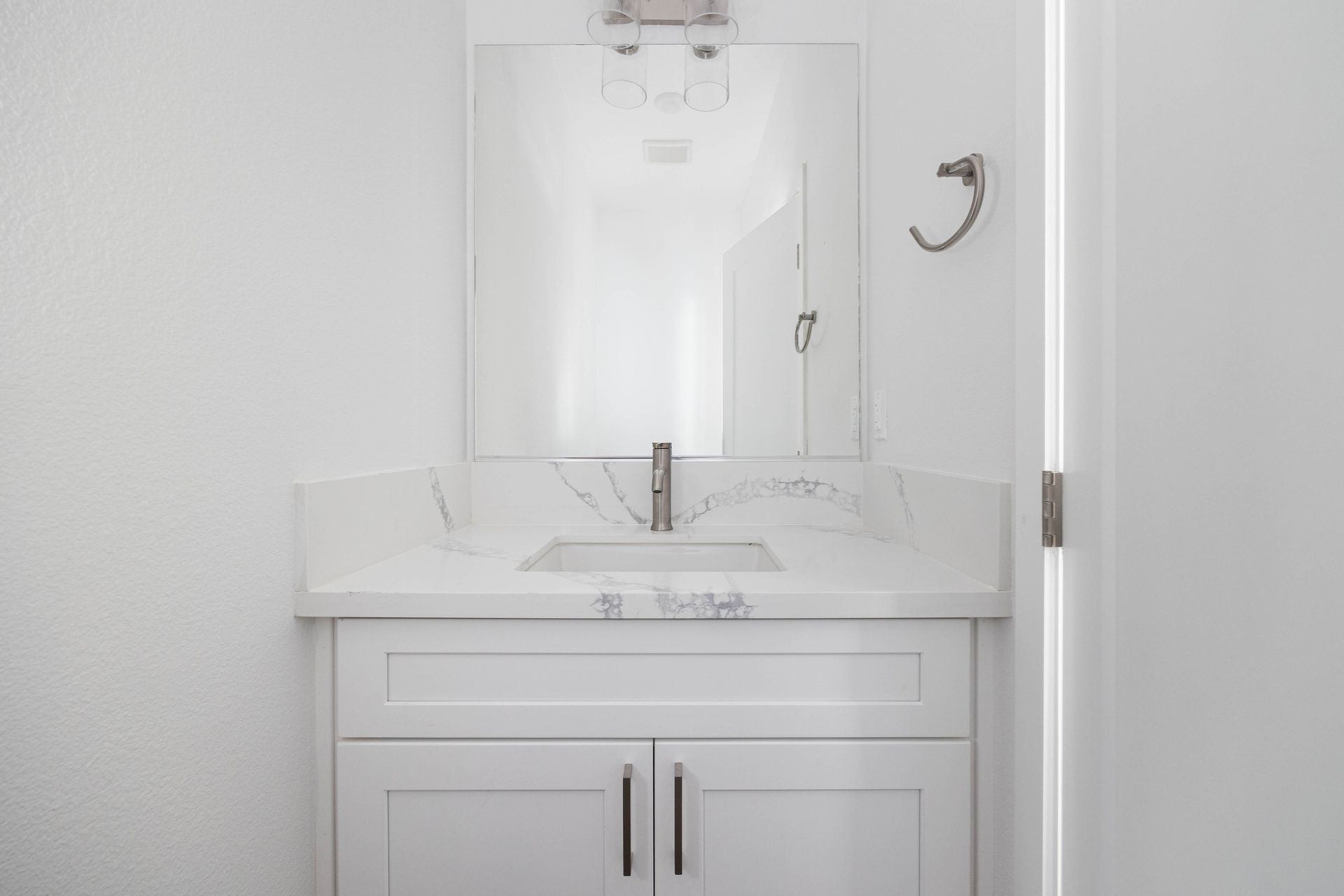 a bathroom with a sink , mirror and cabinets .
