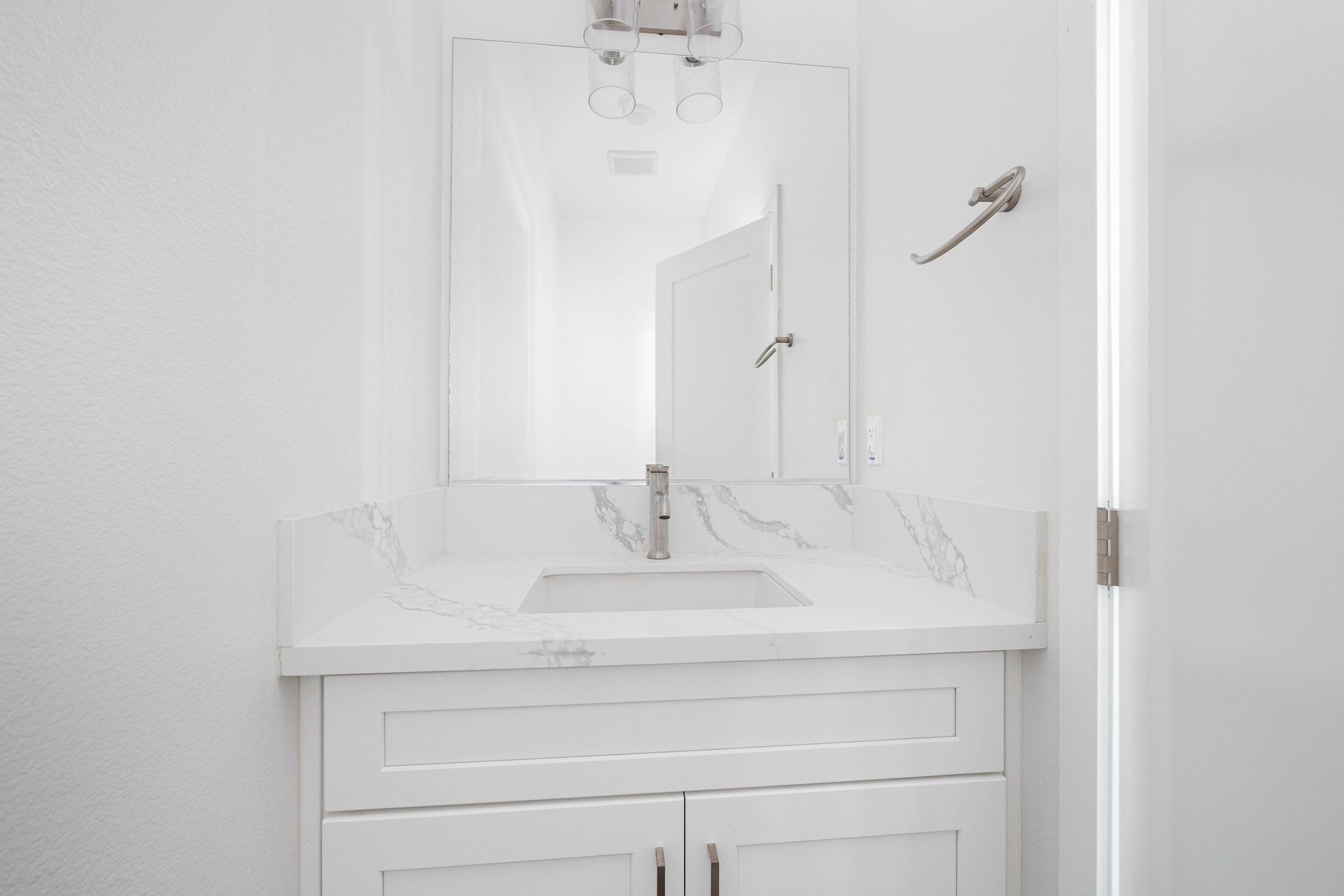 a bathroom with a sink , mirror and cabinets .