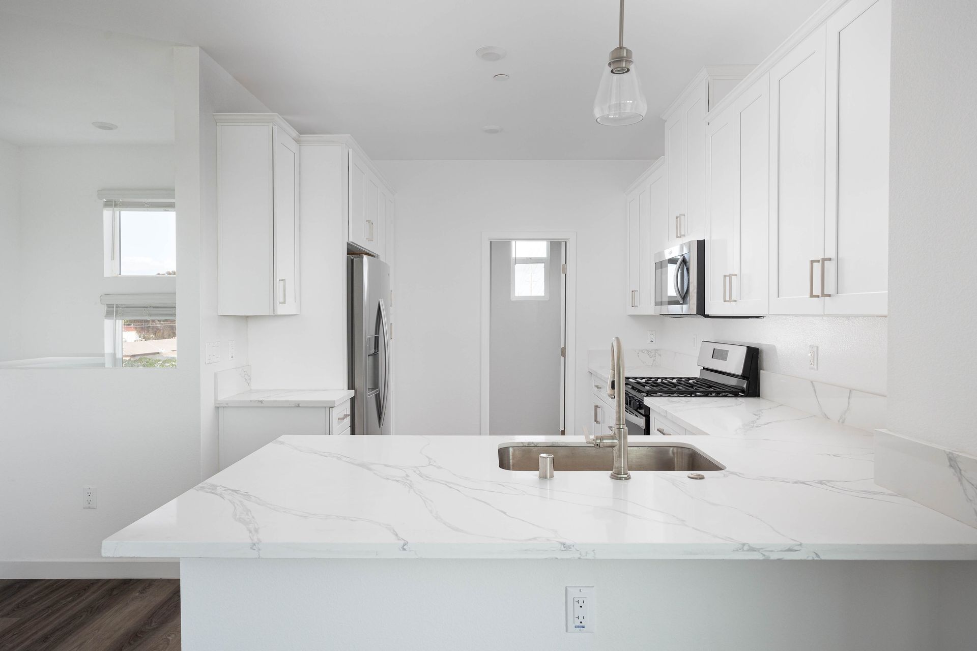 a kitchen with white cabinets , a sink , and a stove .