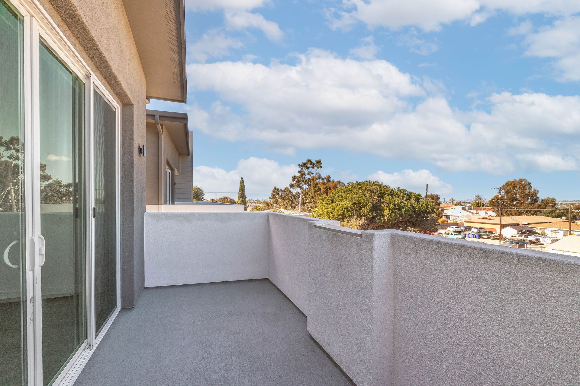 a balcony with sliding glass doors and a view of a city