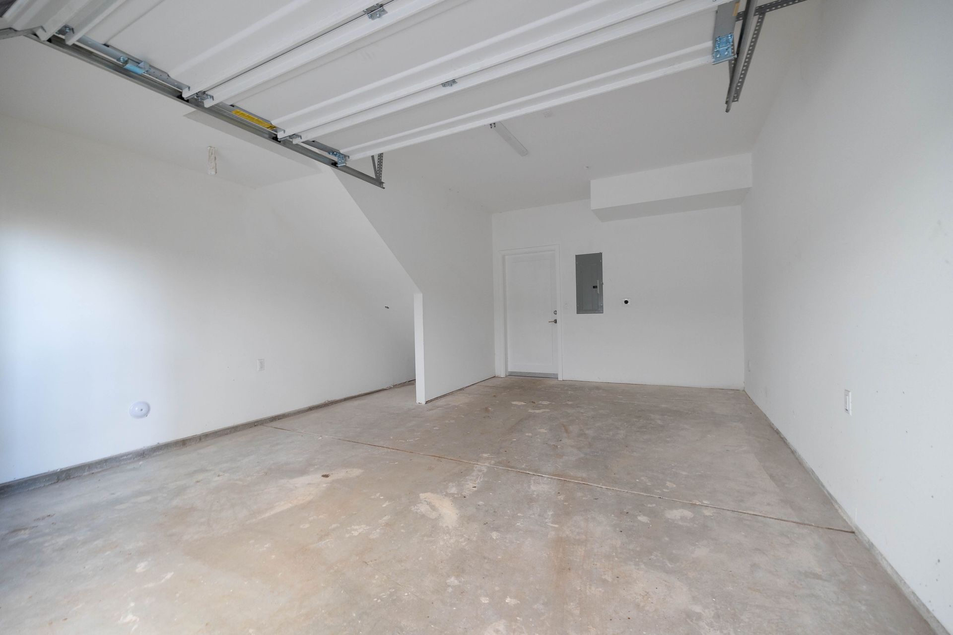 an empty garage with white walls and a concrete floor