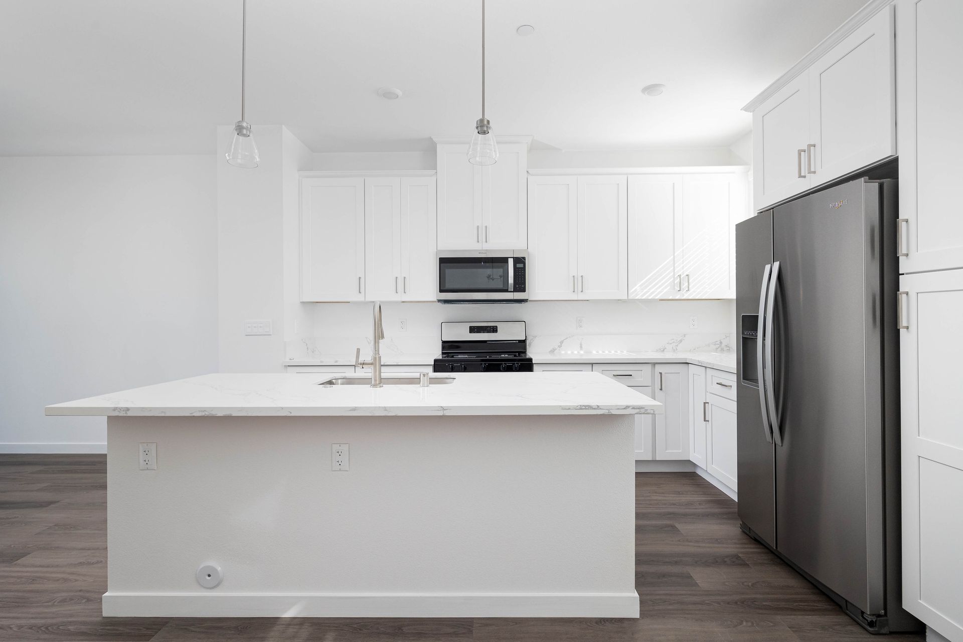 an empty kitchen with white cabinets and stainless steel appliances .