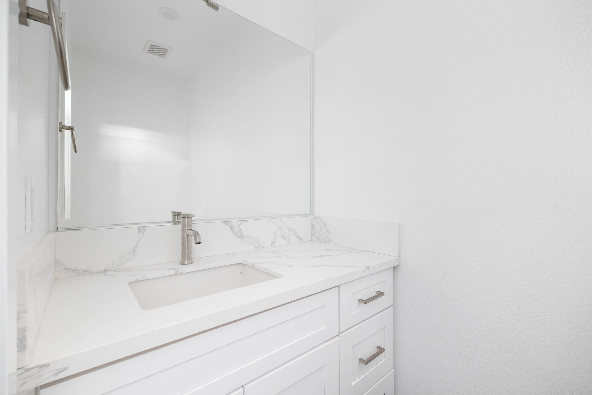 a bathroom with a sink , mirror and cabinets .
