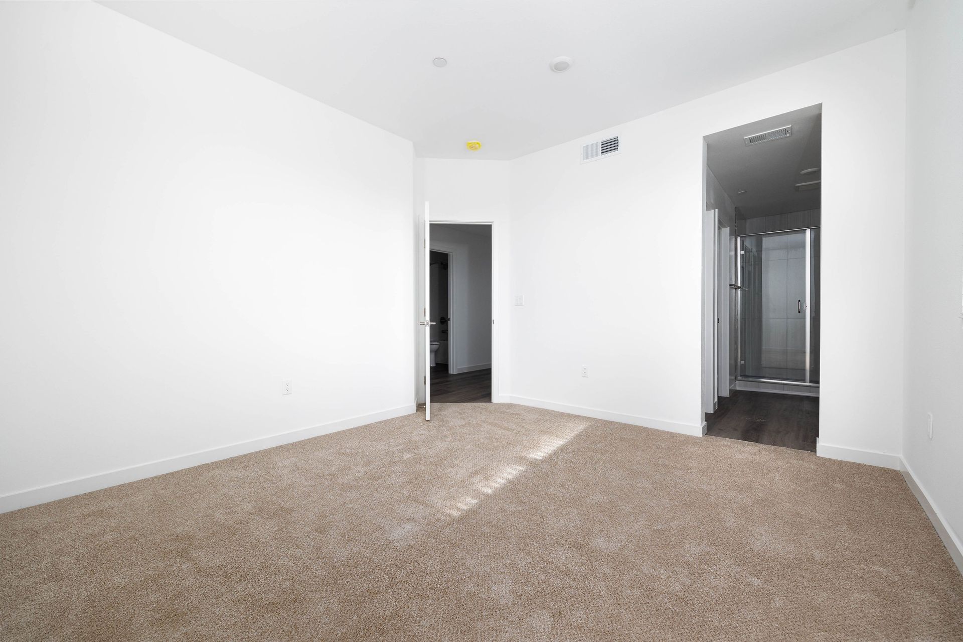 an empty room with a carpeted floor and white walls .
