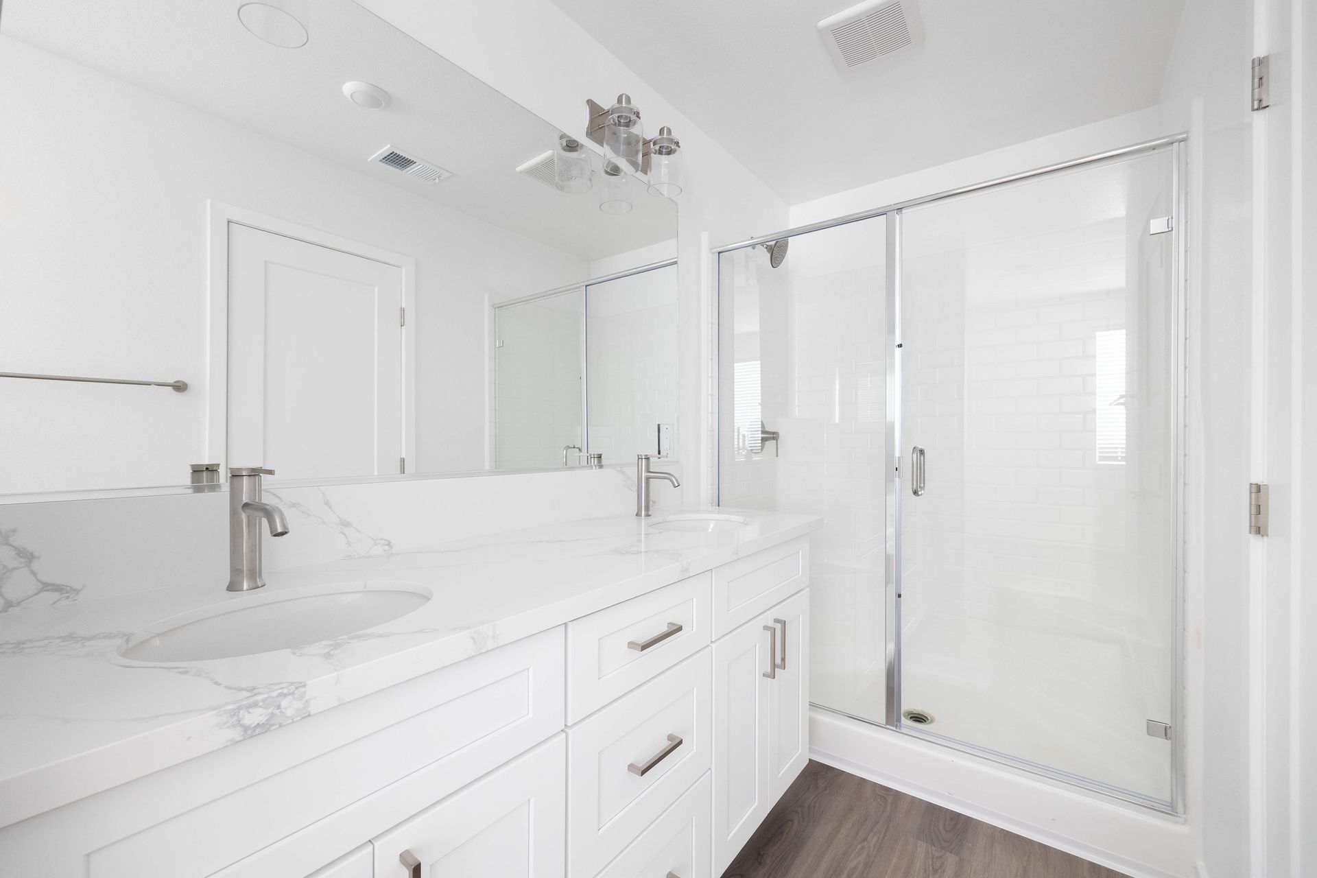 a bathroom with two sinks and a walk in shower .