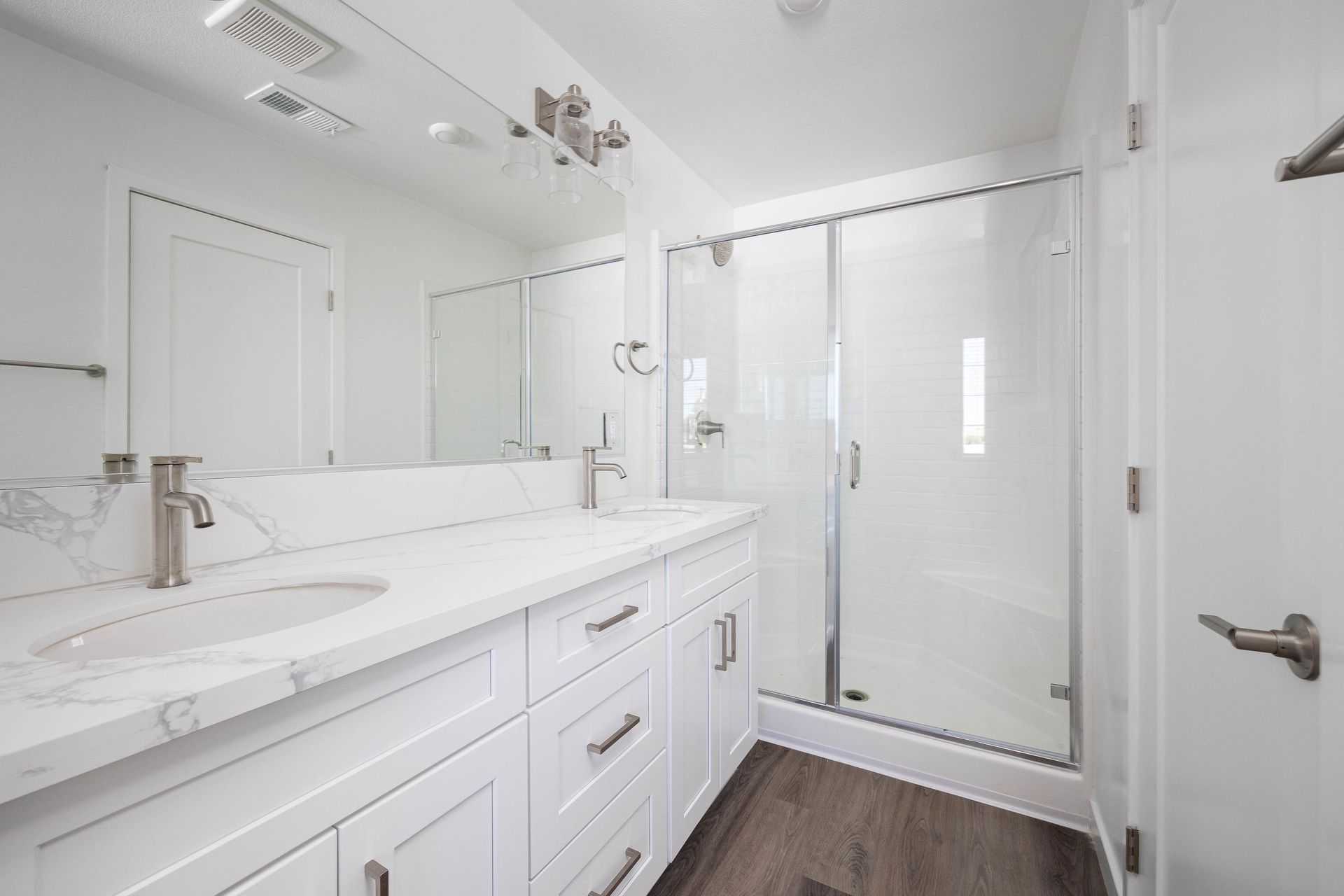 a bathroom with two sinks and a walk in shower .