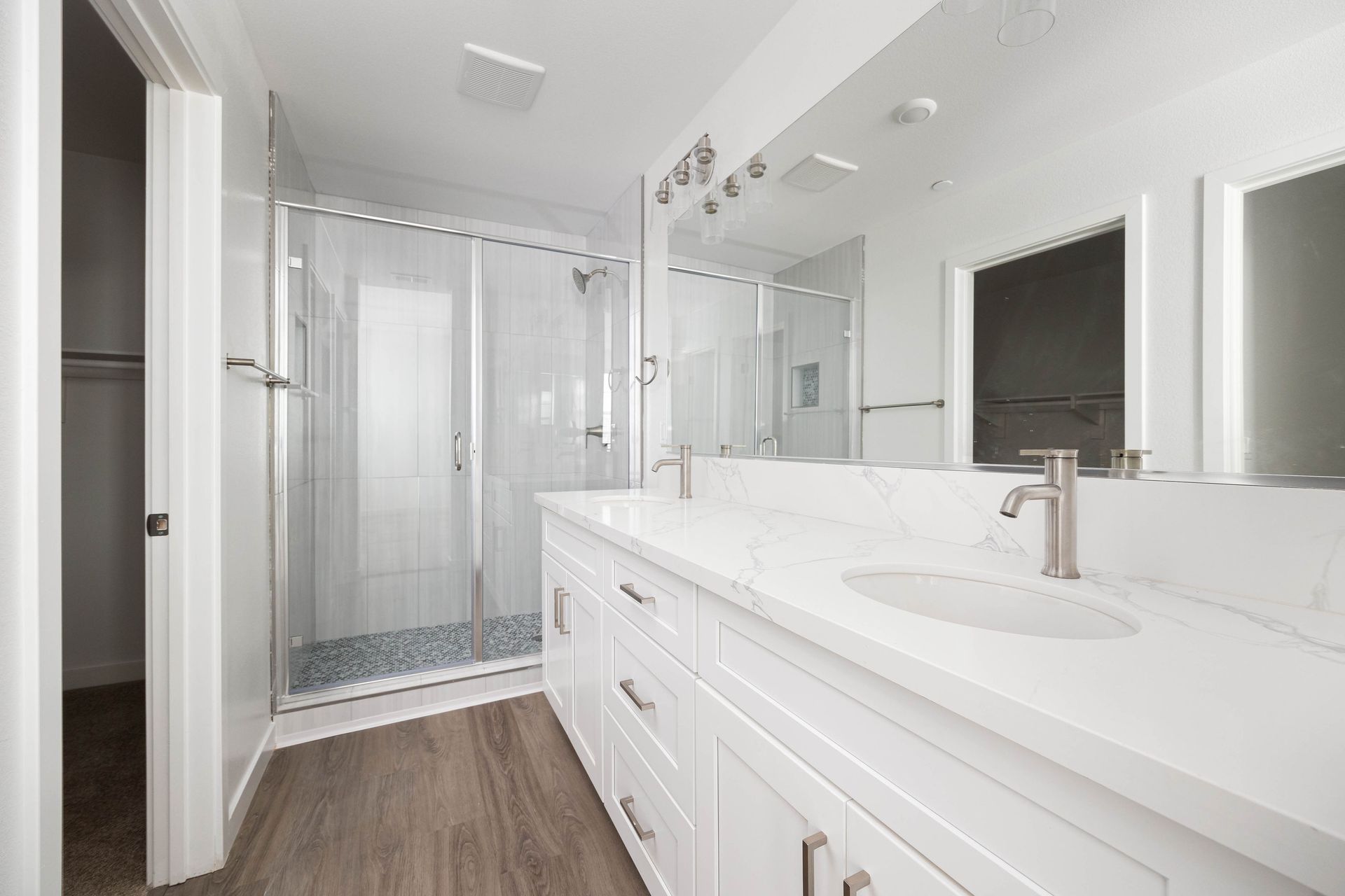 a bathroom with two sinks and a walk in shower .
