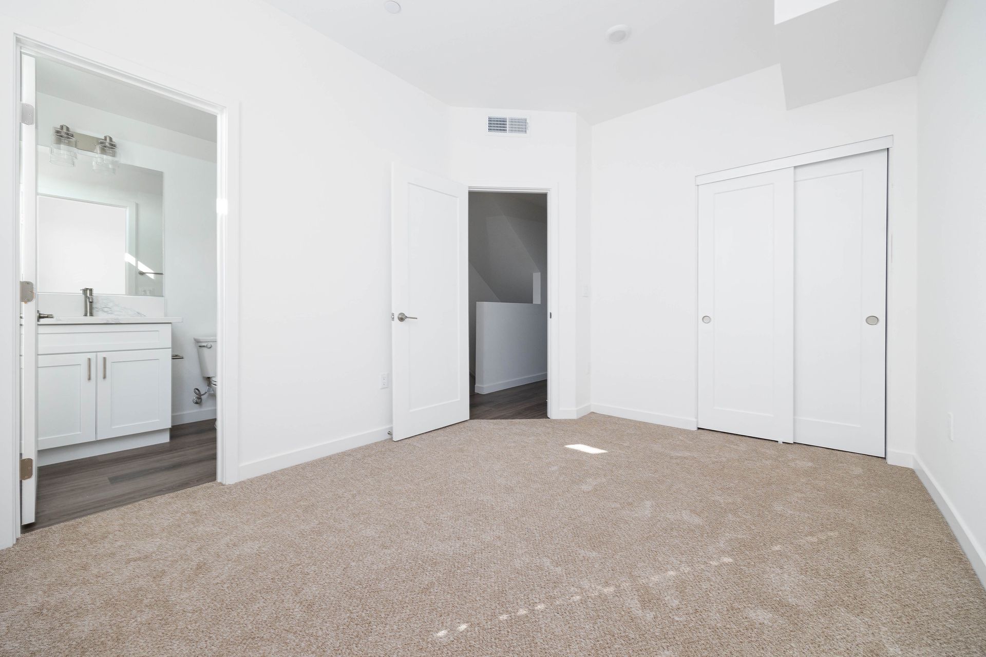 an empty bedroom with a bathroom and closets .