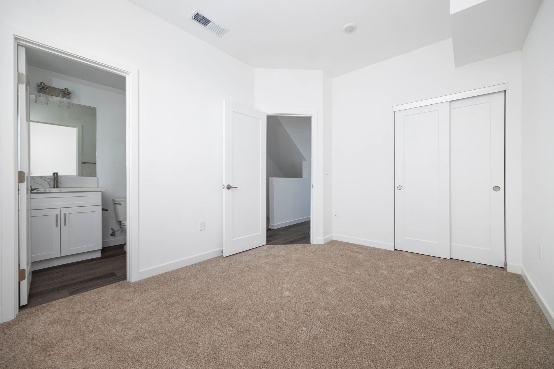 an empty bedroom with a bathroom and closets .