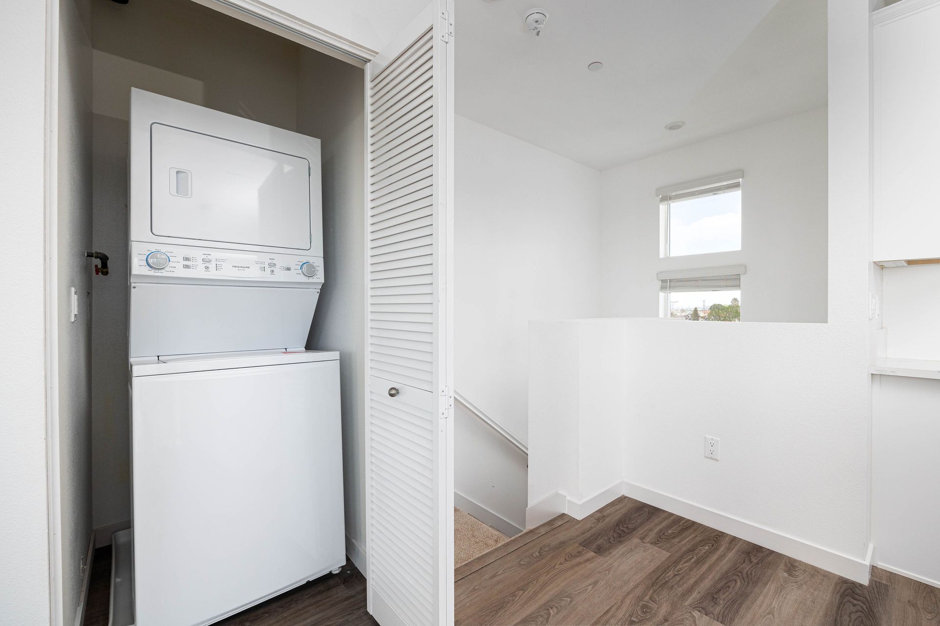 a washer and dryer are stacked on top of each other in a closet .