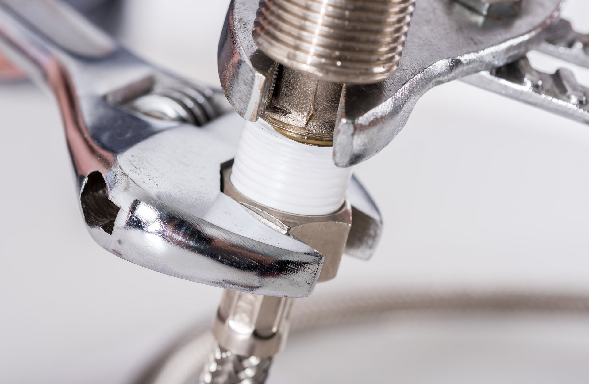 A person is working on a metal gutter with a saw.