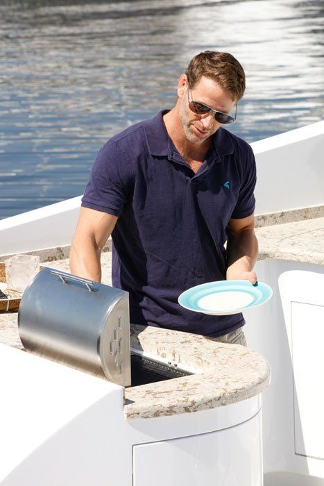 A man is standing on a boat holding a plate