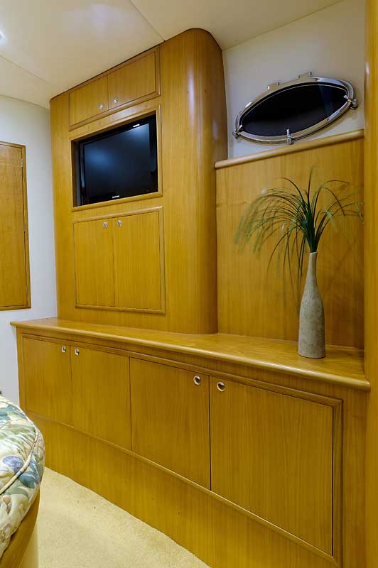 A room with wooden cabinets and a flat screen tv on the wall.