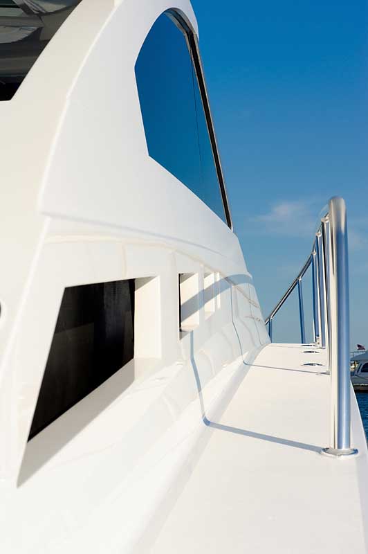 A white boat is docked in the water with a blue sky in the background.