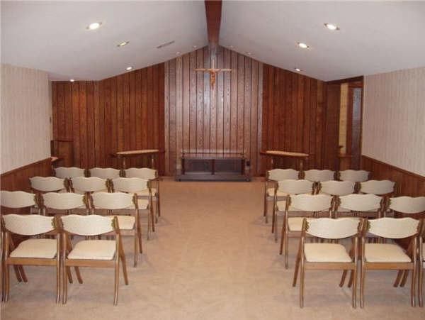 A church with rows of chairs and a cross on the wall