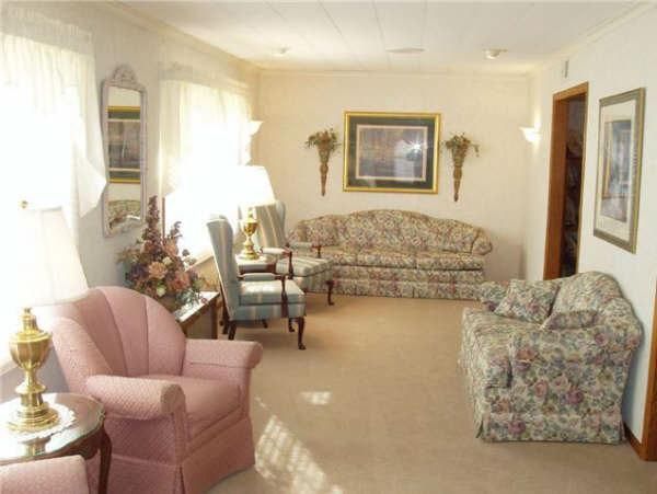 A living room with pink chairs and a couch
