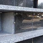 A close up of a row of granite shelves in a cemetery.