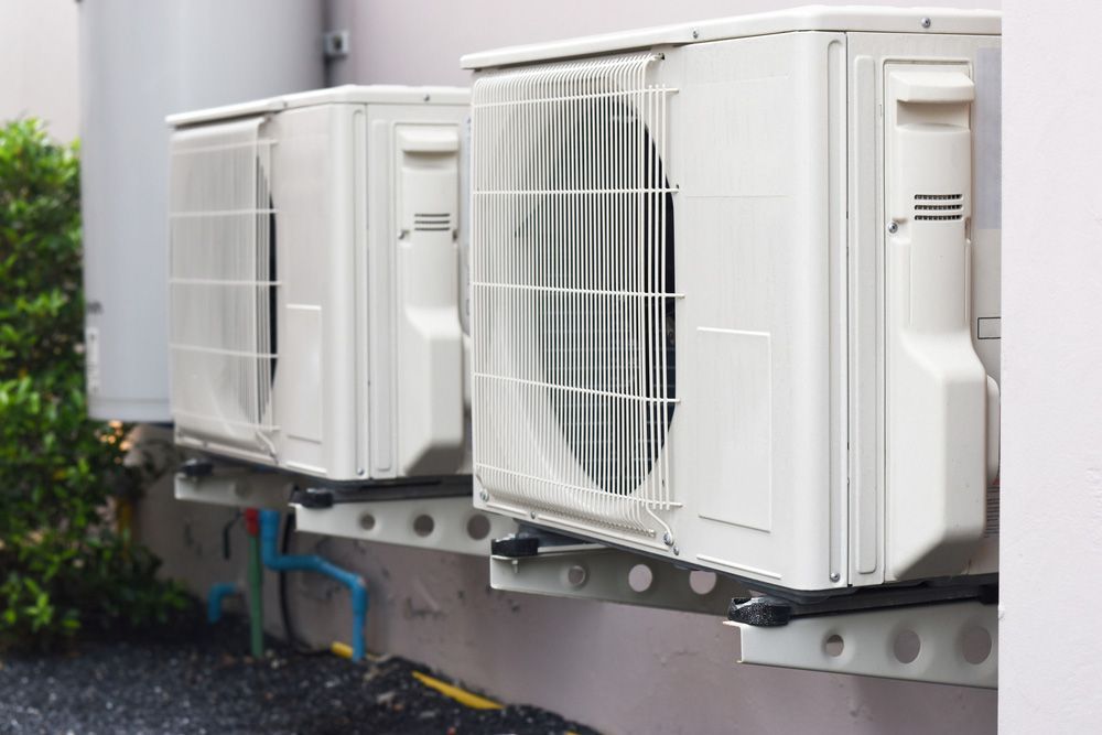 Three Air Conditioners Are Mounted on the Side of a Building — Himec Electrical In Withcott, QLD