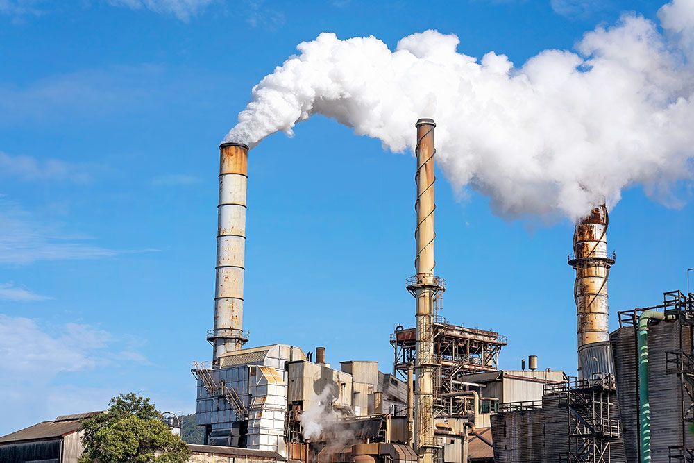 A Factory With Smoke Coming Out of the Chimneys — Himec Electrical In Withcott, QLD