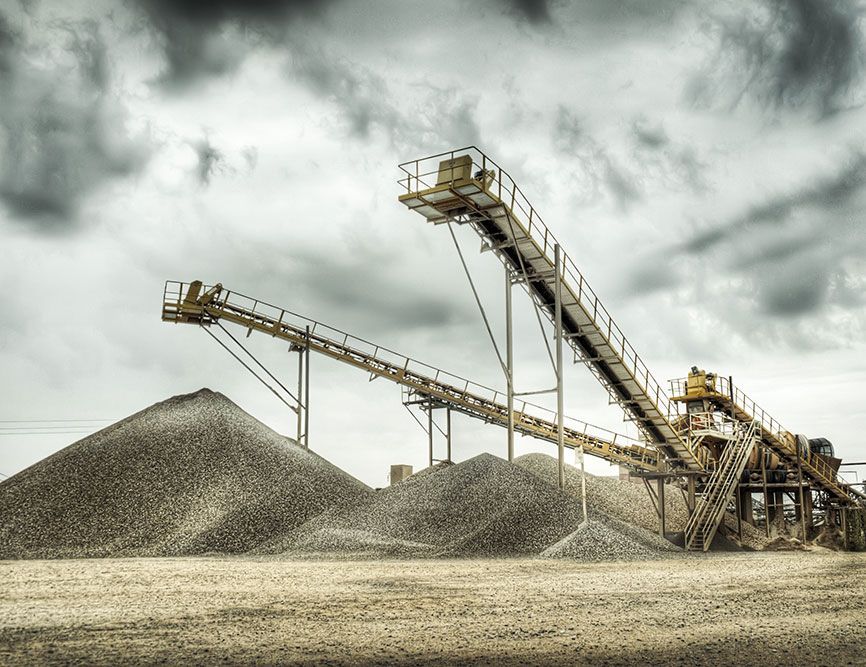 A Conveyor Belt is Going Over a Pile of Rocks — Himec Electrical In Withcott, QLD
