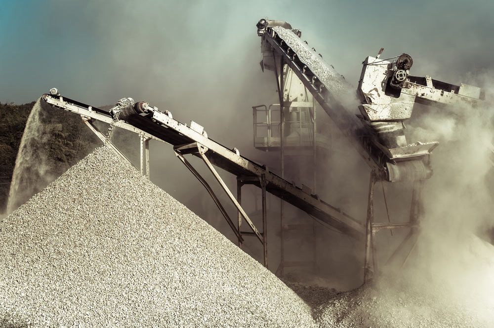A Pile of Gravel is Being Moved by a Conveyor Belt in a Factory — Himec Electrical In Withcott, QLD