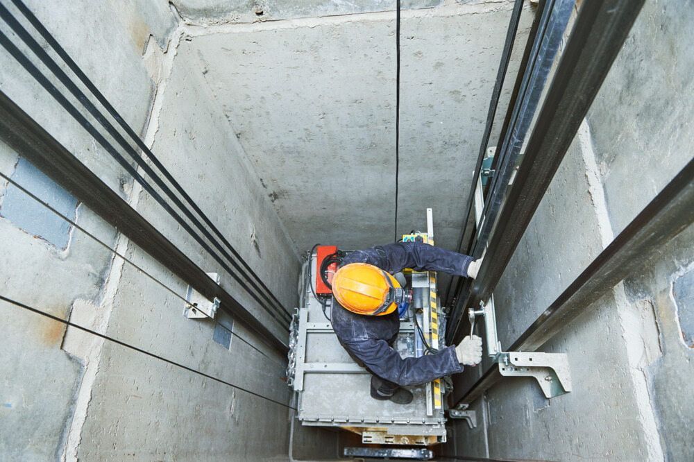 A Man in a Hard Hat is Working on an Elevator — Himec Electrical In Withcott, QLD