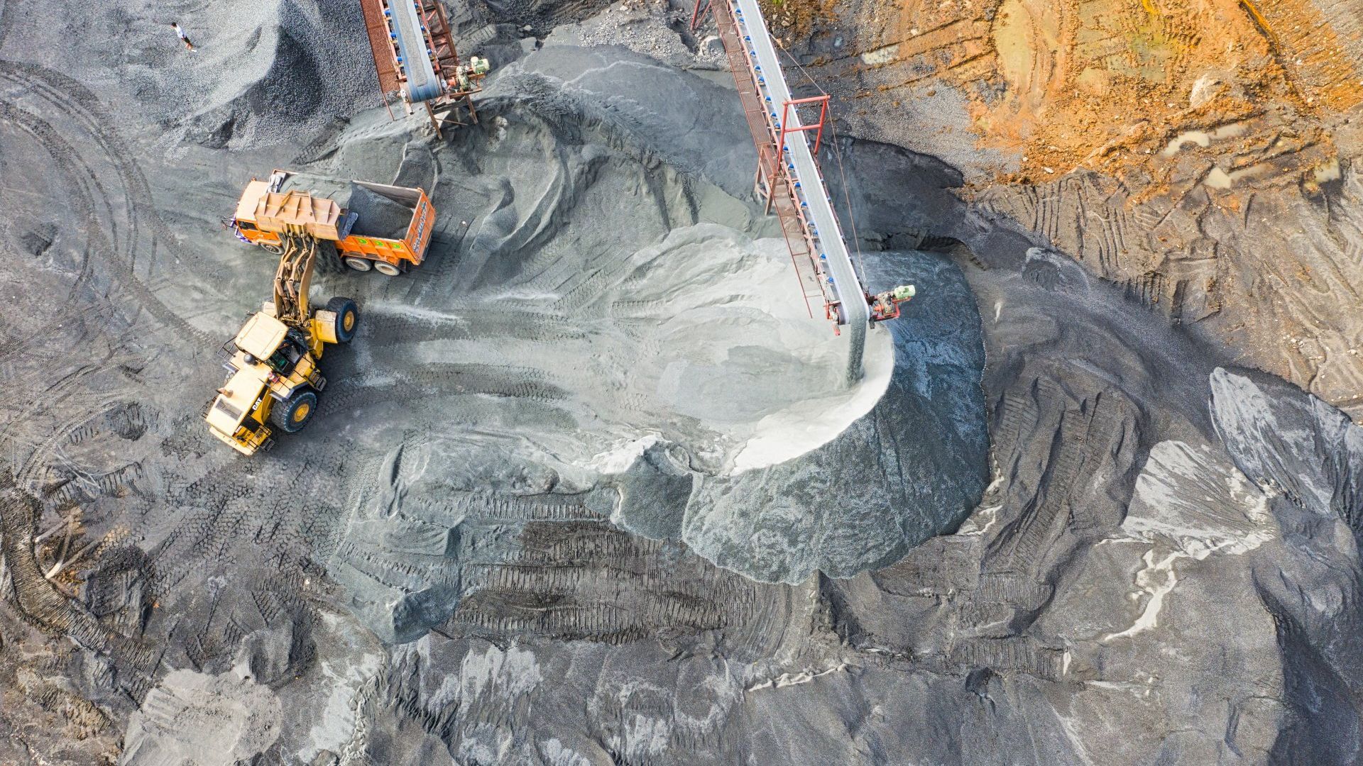 An aerial view of a construction site with a bulldozer and a conveyor belt.