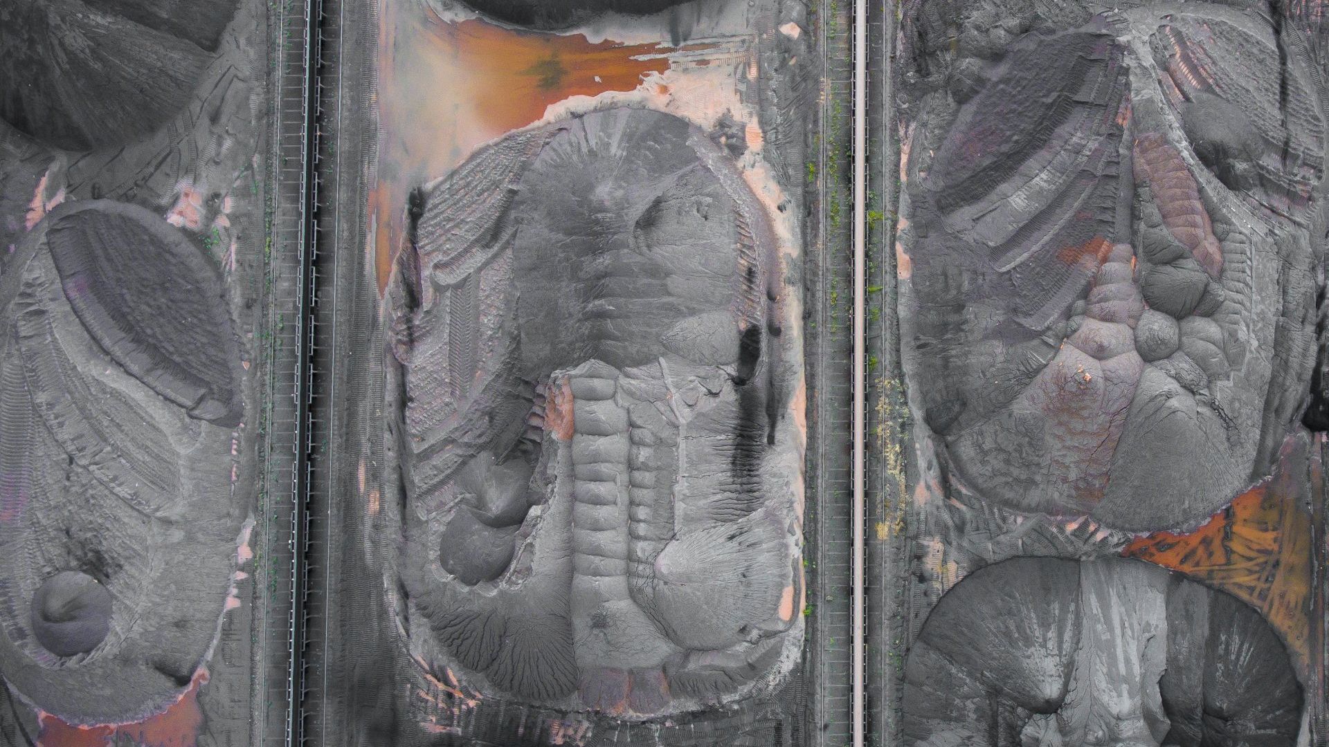 A close up of three sculptures of faces on a wall.