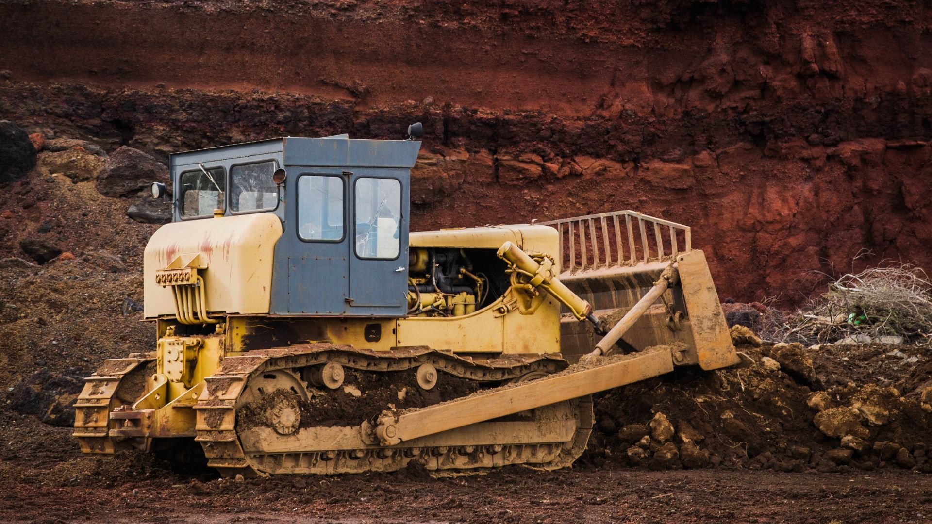 A bulldozer is sitting on top of a dirt field.