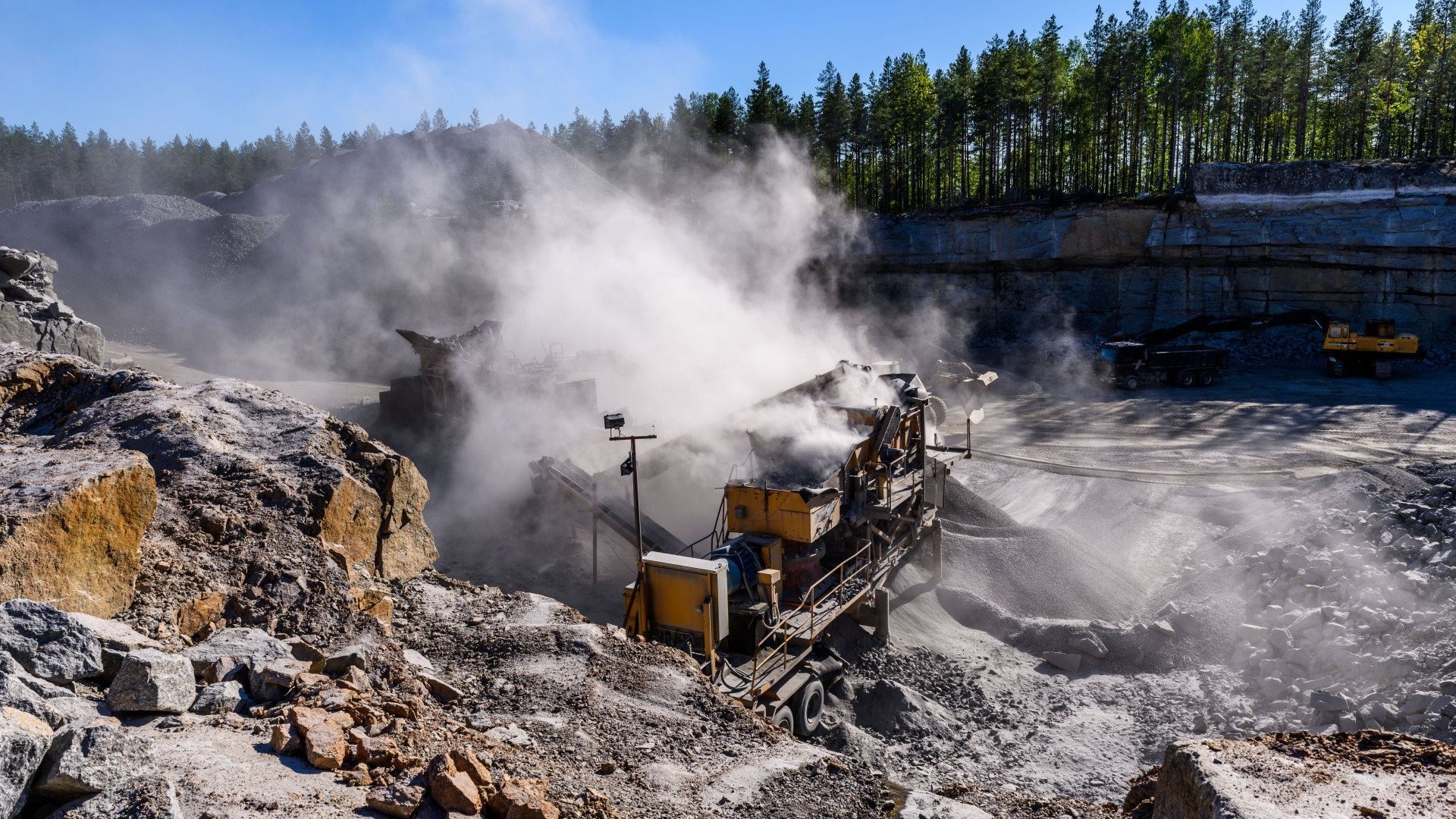 A large rock quarry with a lot of dust coming out of it.