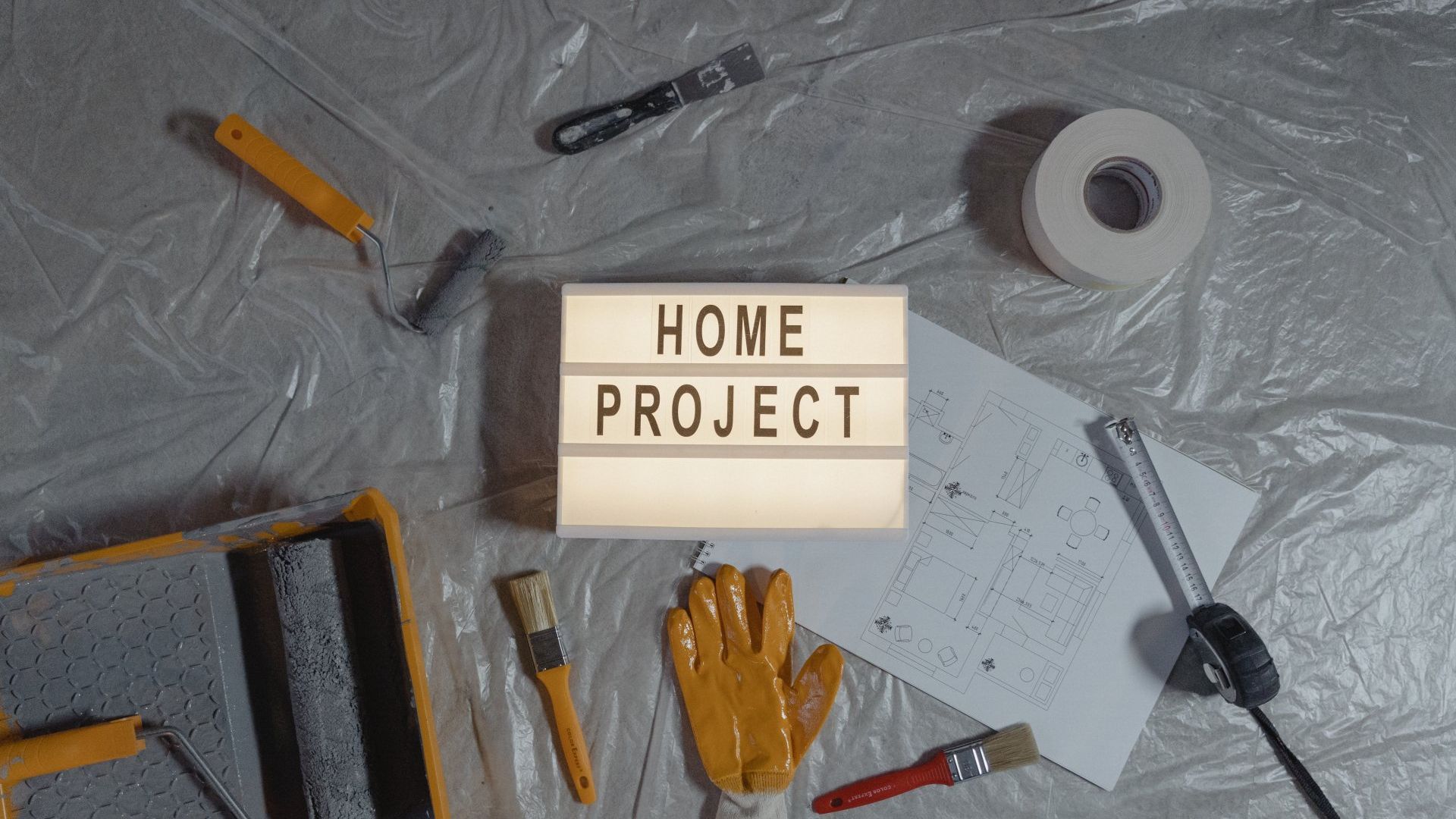 A light box with the words `` home project '' written on it is surrounded by tools.