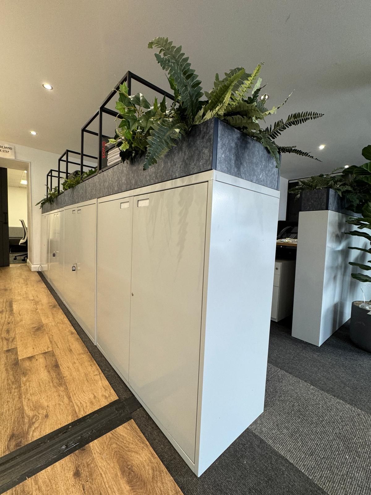 White cabinets with plants on top in an office.