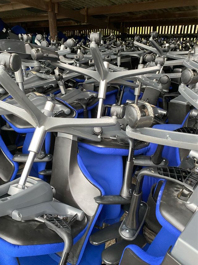 Blue task chairs stacked under cover before stripping