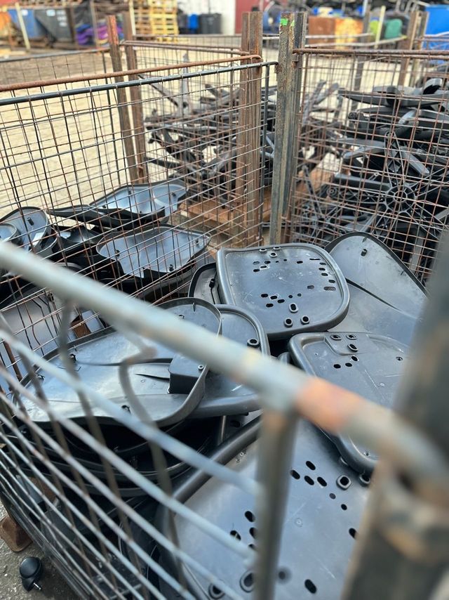 Plastic seat pans in a steel stillage after foam and fabric were removed