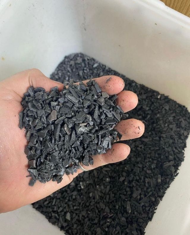 A handful of shredded plastic regrind ready for reprocessing