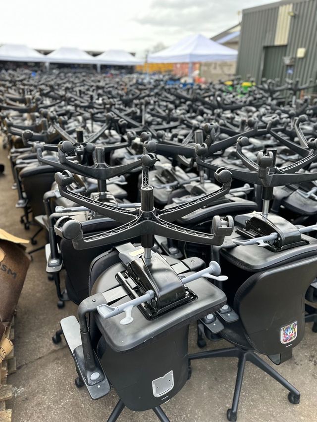 Hundreds of task chairs from clearances lined up in the yard for grading