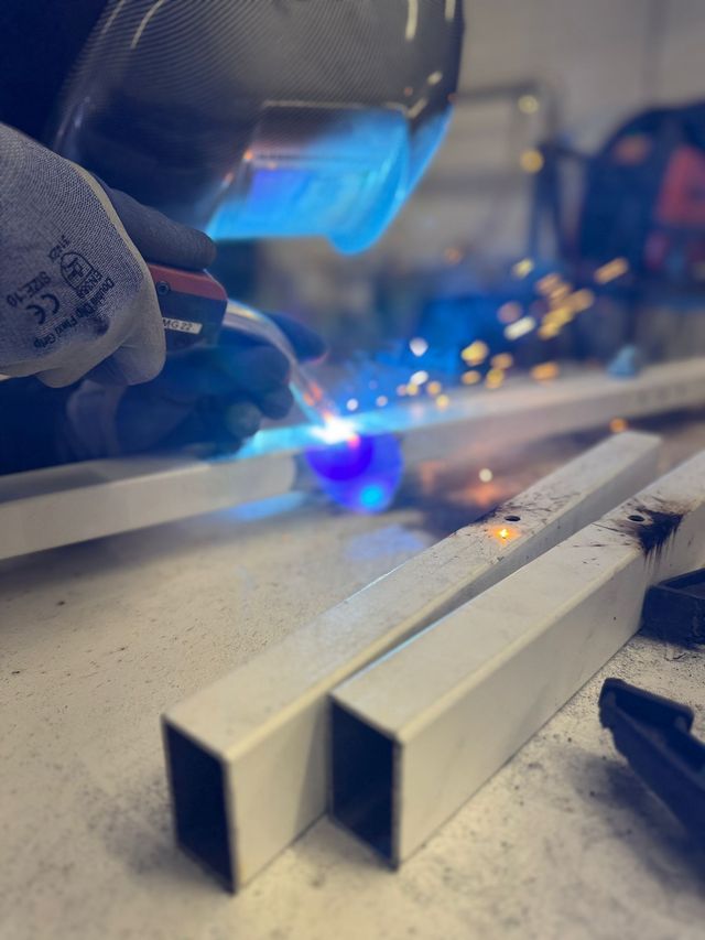 A steel desk frame being welded