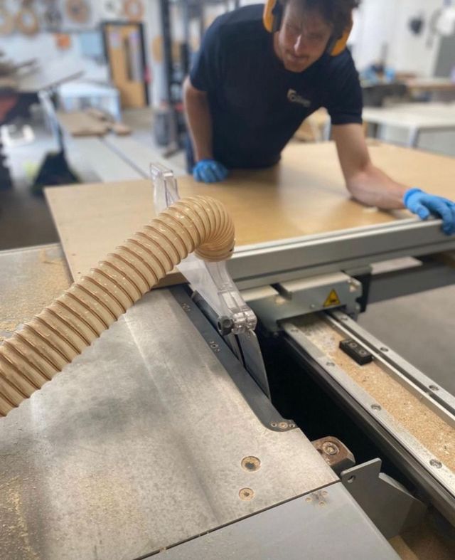 A cut desk top going through the edge bander