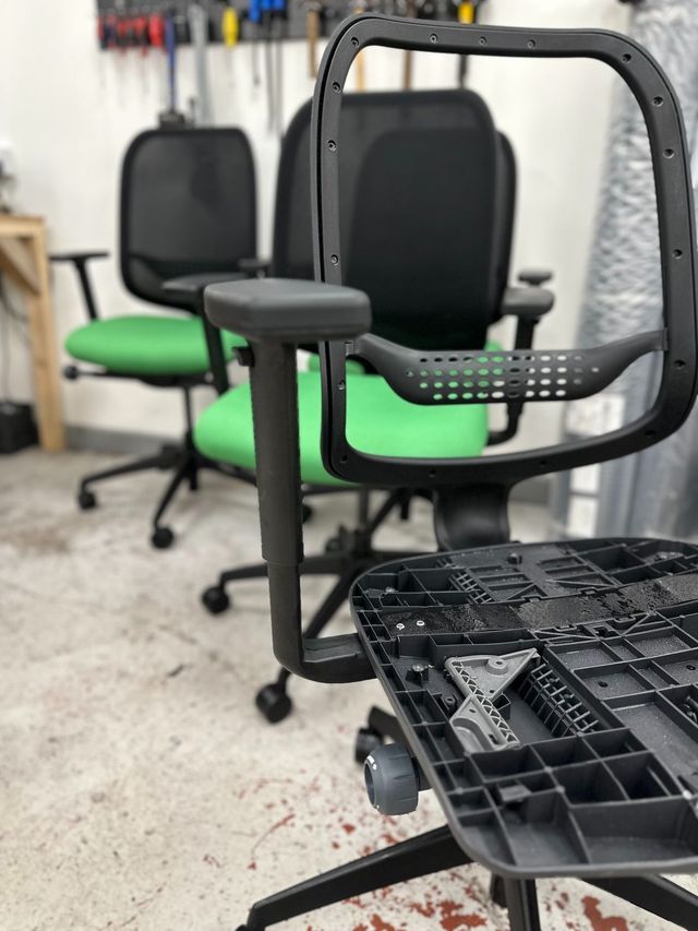 Refurbished task chairs with new green seat fabric in the workshop