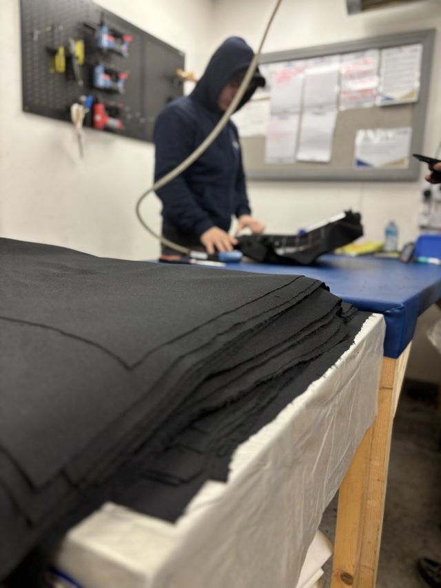 Upholstery fabric being cut on the bench