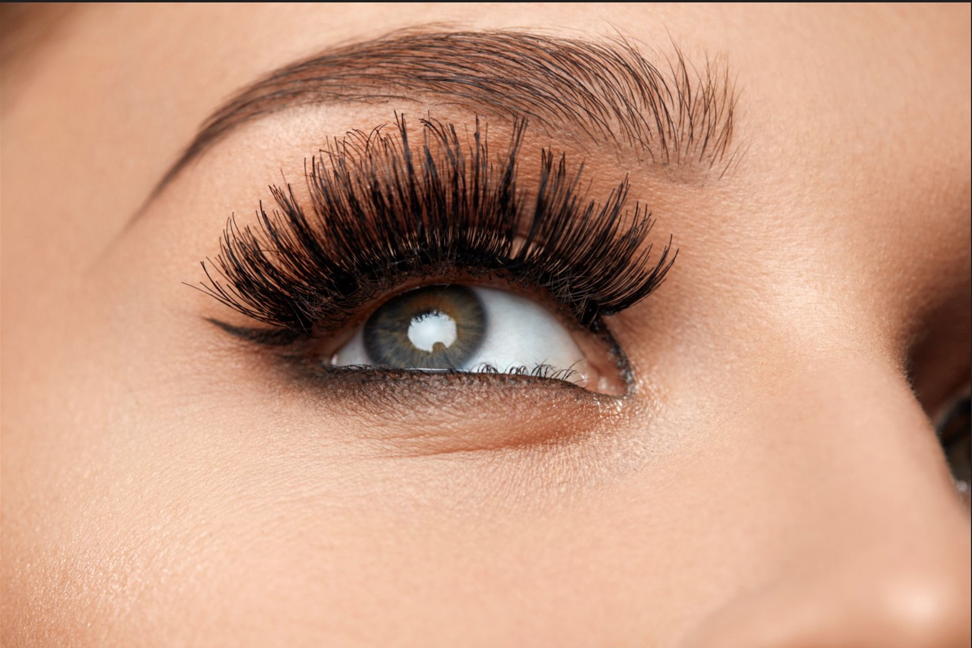 A close up of a woman 's eye with long eyelashes.