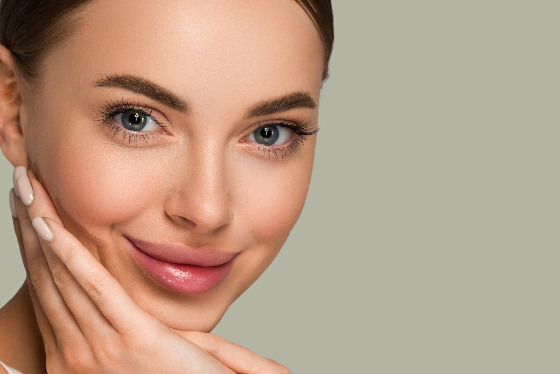 A close up of a woman 's face with her hands on her face