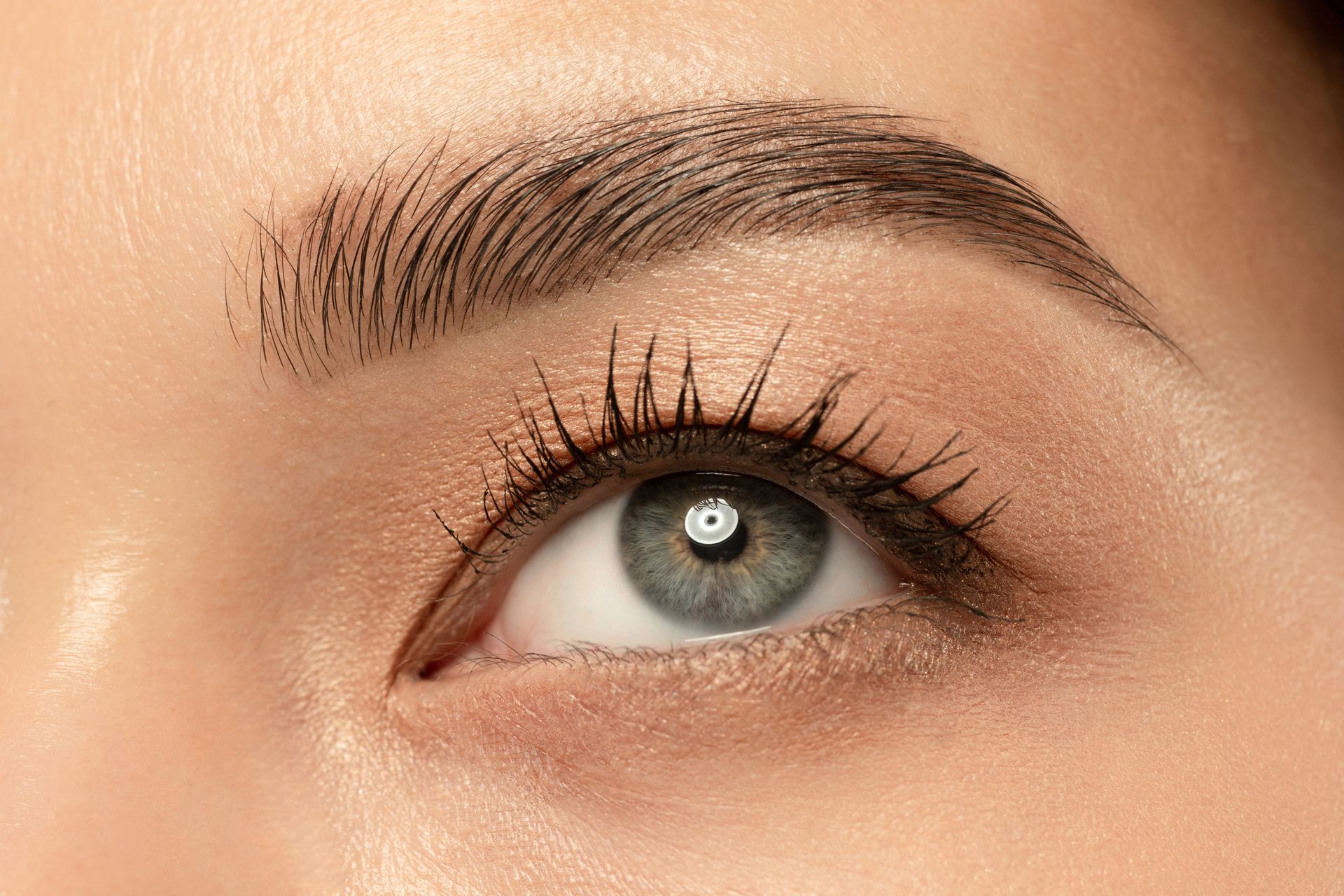 A close up of a woman 's eye with mascara and eyebrows.