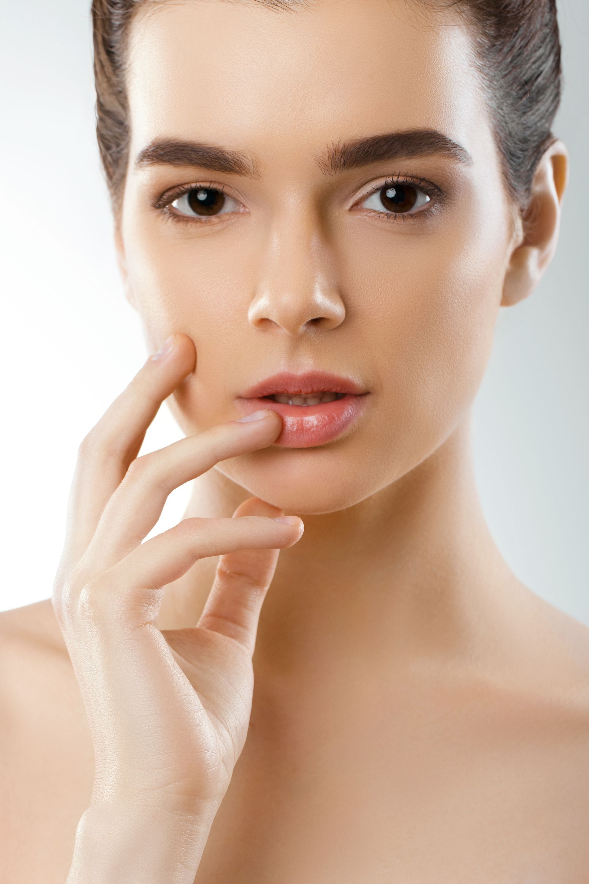 A close up of a woman 's face with her hand on her chin.