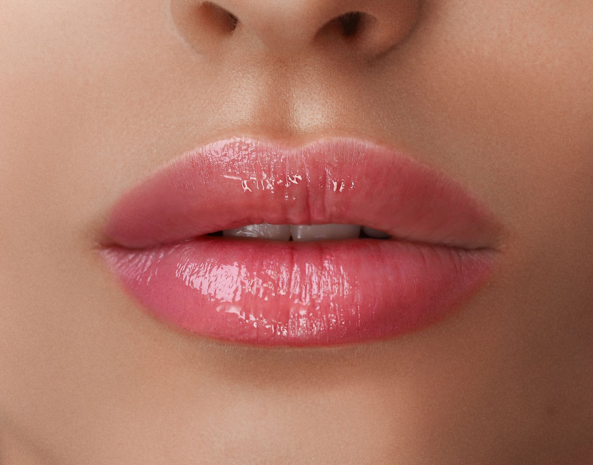 A close up of a woman 's lips with pink lipstick.