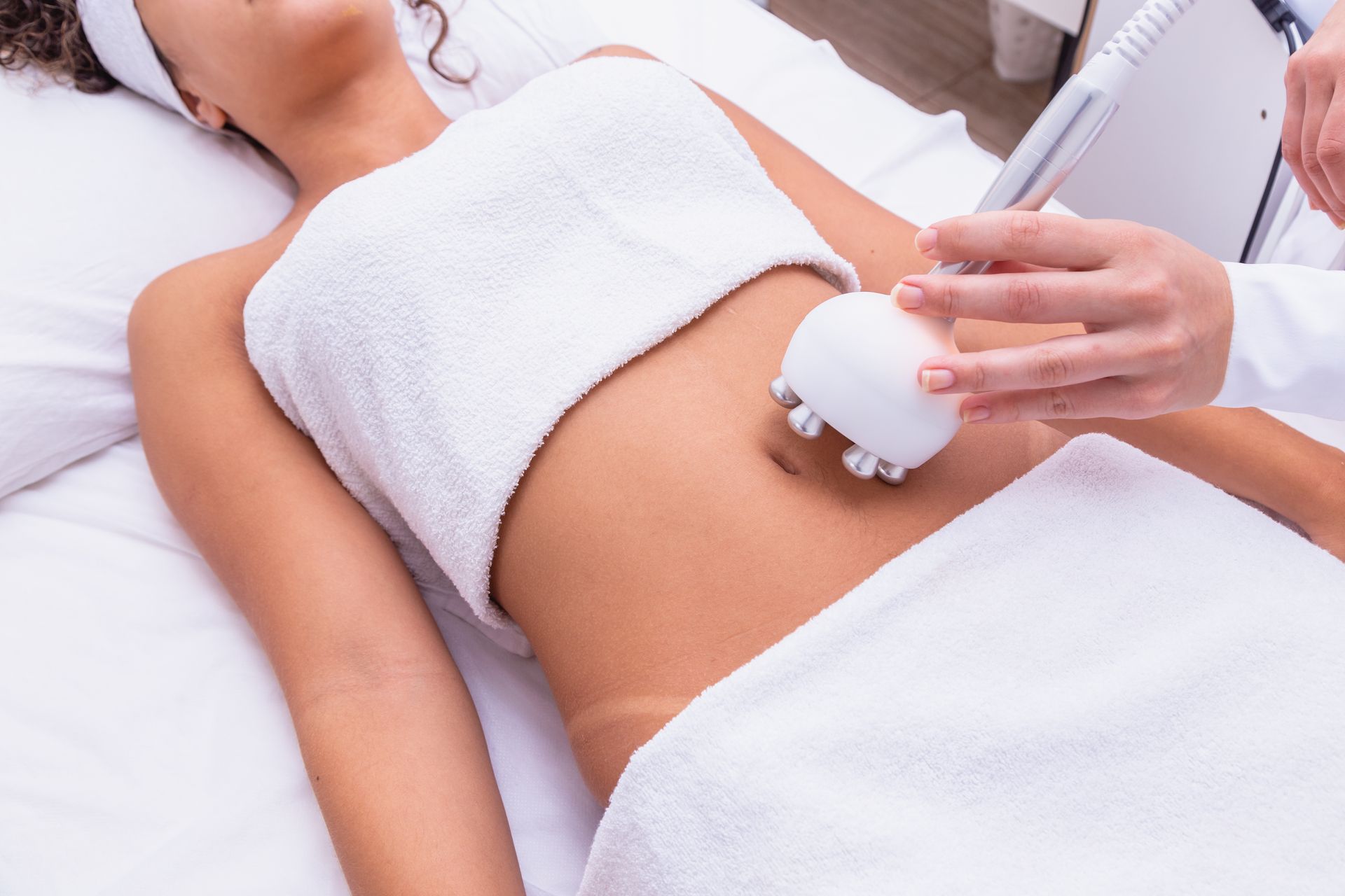 A woman is laying on a bed getting a massage on her stomach.