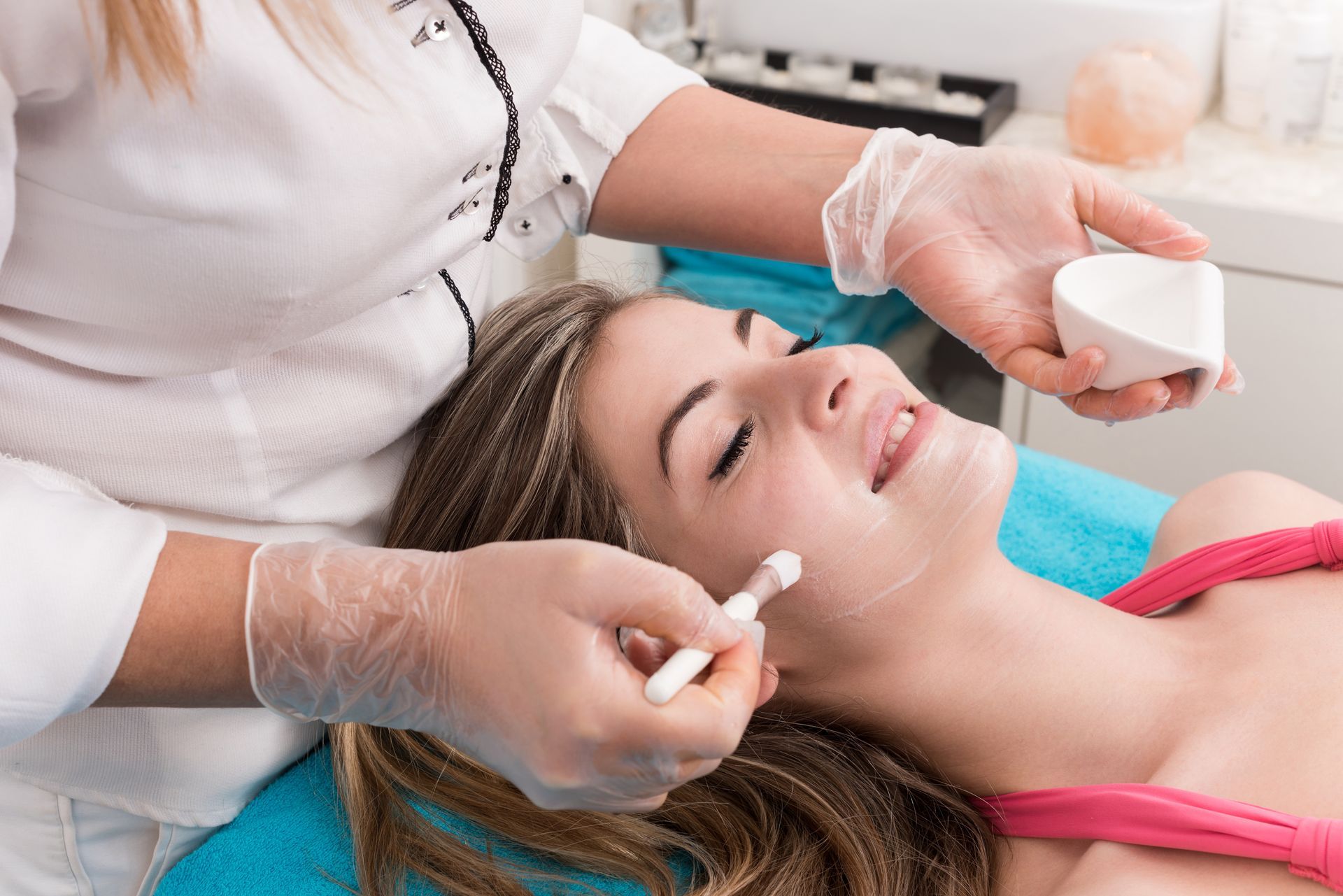 A woman is getting a facial treatment at a beauty salon.