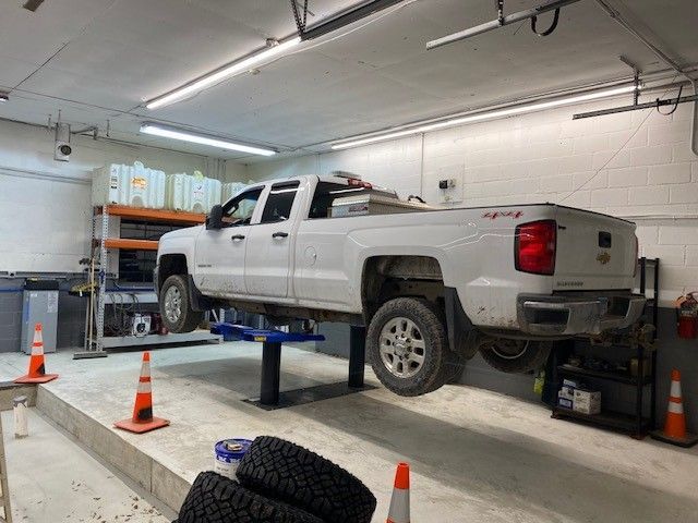 A row of cars with their hoods off and tires on the ground