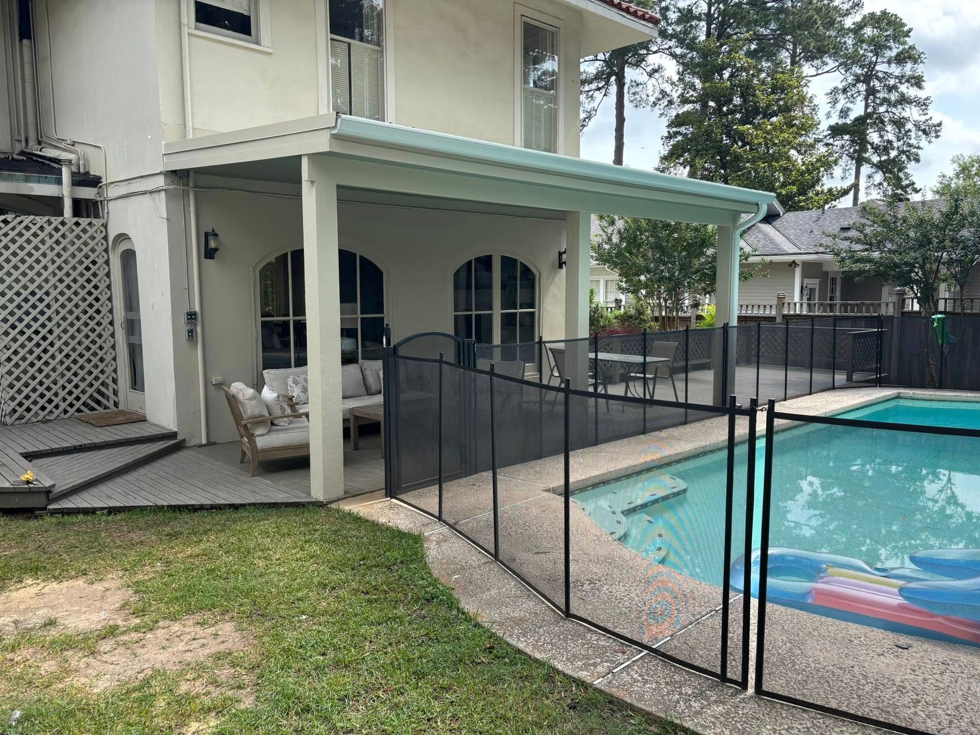 A house with a swimming pool and a fence around it.